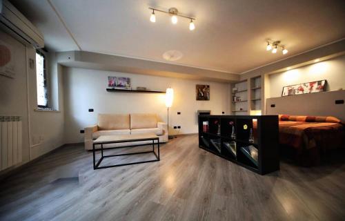 a bedroom with a bed and a couch and a chair at Appartamento Aleph in Como