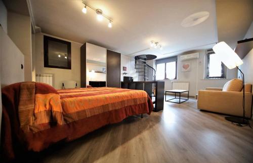 a bedroom with a bed and a chair and a couch at Appartamento Aleph in Como