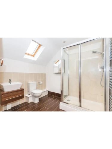 a bathroom with a shower and a toilet and a sink at 9 College Court Spacious, Modern 4-Bed Townhouse in York - Pass the Keys in York