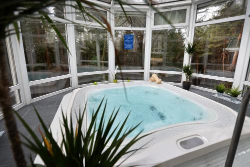 a jacuzzi tub in a house with windows at Panorama Hotel Noszvaj in Noszvaj