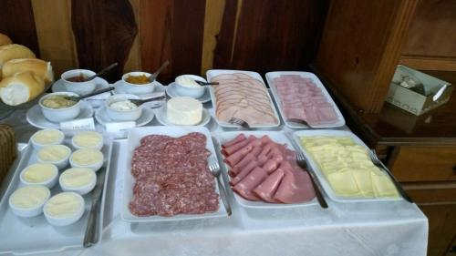 a table with different types of meats and other foods at Kontiki Hotel in São Francisco do Sul