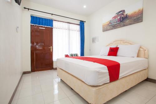a bedroom with a large bed and a window at RedDoorz @ Panglima Sudirman Probolinggo in Probolinggo