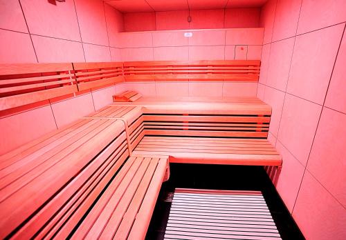a room with wooden benches in a red room at Résidence Ôtelia Affaires & Bien-être in Lyon