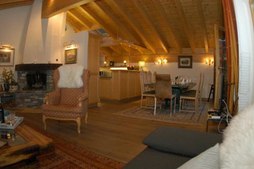 a living room with a kitchen and a dining room at Chalet Guggenbiel in Zermatt