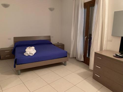 sypialnia z łóżkiem z niebieską narzutą w obiekcie Park 20 Appartamento w mieście Olbia
