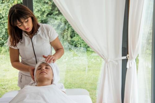 a woman standing next to a man in a hospital bed at Monsignor Della Casa Country Resort & Spa in Borgo San Lorenzo