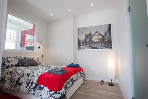 sypialnia z łóżkiem i zdjęciem na ścianie w obiekcie WindRose 8 w Madrycie