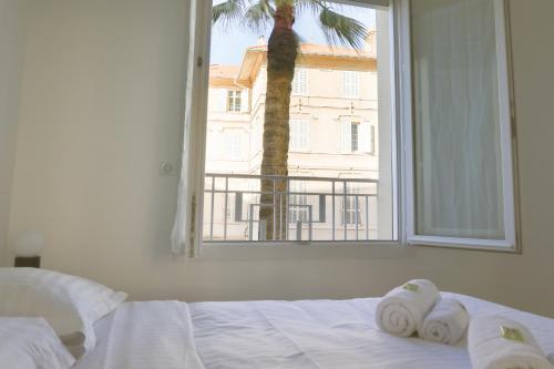 - une chambre avec un lit, des serviettes et une fenêtre dans l'établissement IMMOGROOM - SEA VIEW - 2 min from beach - CONGRESSBEACHES, à Cannes