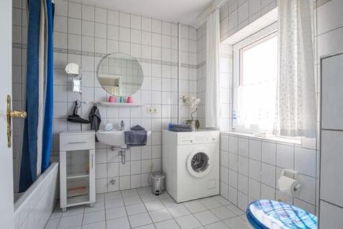 a bathroom with a washing machine and a sink at Apartment Radmokerhuus in Pellworm