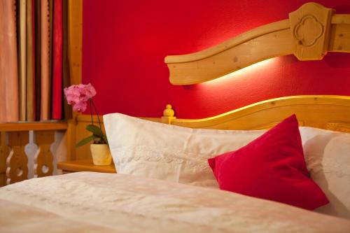 a bedroom with a bed with a red wall at Familienhotel Lengauer Hof in Saalbach-Hinterglemm