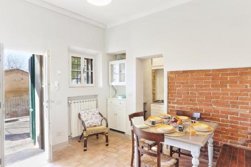 a dining room with a table and a brick wall at Borgo di Alica in Palaia