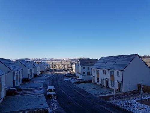 a street with houses and a car on the road at 9 Royal View Apartment in Stirling