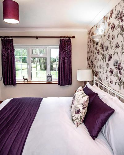 a bedroom with a large bed and a window at Trivelles Waterhall Country Gatwick Hotel & airport parking in Crawley