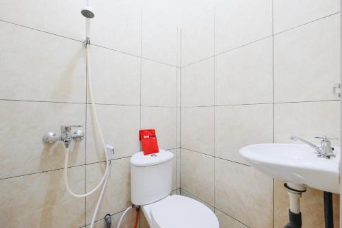 スマランにあるRedDoorz near Universitas Diponegoro Semarangの白いトイレと洗面台のあるバスルーム