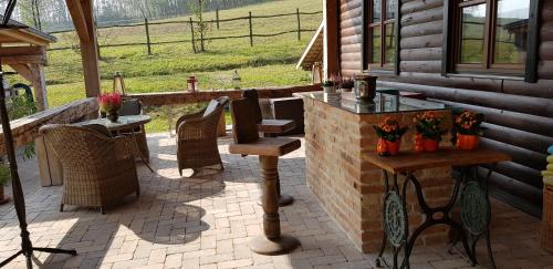 a patio with a table and chairs on a house at Bársonyberek vendégház Bakony in Jásd
