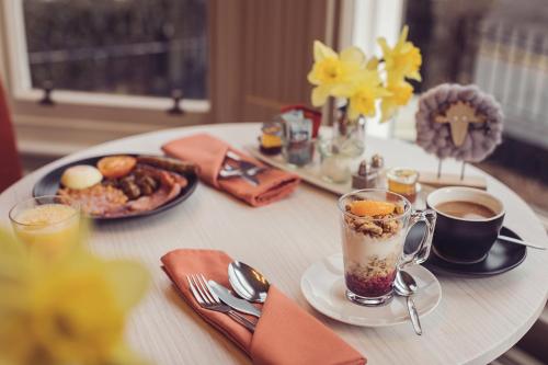 a table with a cup of coffee and a plate of food at Ambleside Townhouse in Ambleside