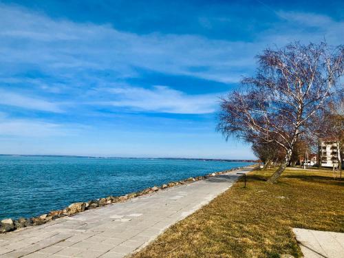 a walkway next to a body of water at Villa Oliver 2 Siófok in Siófok