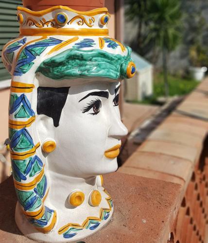 a statue of a woman with a green hat at Loft Karol Taormina in Gaggi