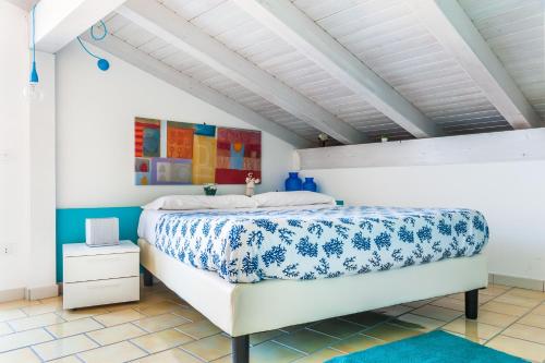 a bedroom with a bed with a blue and white bedspread at Settessenze Residence & Rooms in Agropoli