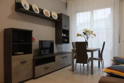 a living room with a dining room table and a television at Sapore di sale, sapore di mare in Chiavari