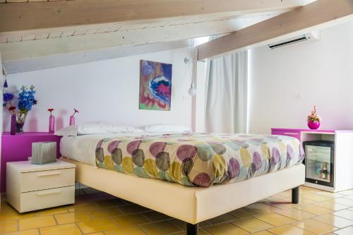 a bedroom with a large bed with a colorful bedspread at Settessenze Residence & Rooms in Agropoli