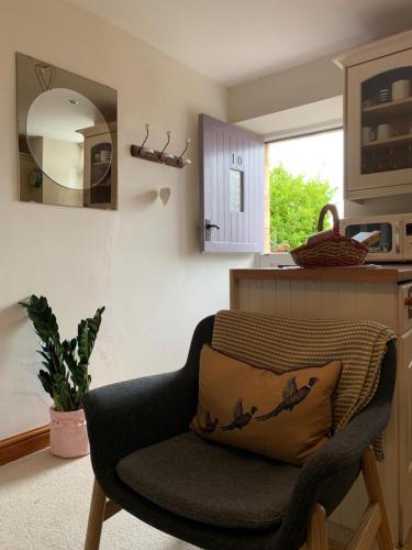 - une chaise avec un oreiller dans la cuisine dans l'établissement Weaver's Cottage @ Number 10, à Bradford-on-Avon
