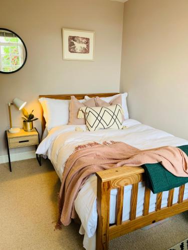 a bedroom with a bed with white sheets and pillows at Weaver's Cottage @ Number 10 in Bradford on Avon