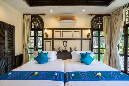 Wora Bura Hua Hin Resort & Spa - SHA Extra Plus tesisinde bir odada yatak veya yataklar