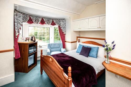 a bedroom with a bed and a desk and a window at Trivelles Waterhall Country Gatwick Hotel & airport parking in Crawley