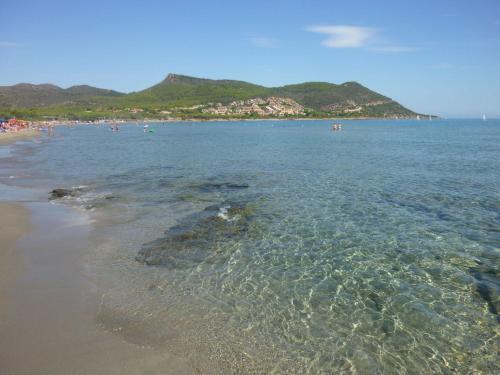 una playa con un grupo de personas en el agua en Corallo Vacanze en Villaputzu