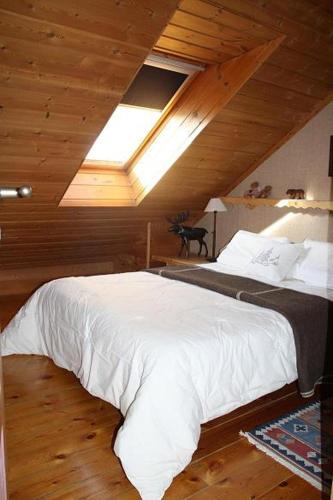 - une chambre avec un grand lit blanc et une lucarne dans l'établissement haut de chalet 6 P villard de lans, à Villard-de-Lans