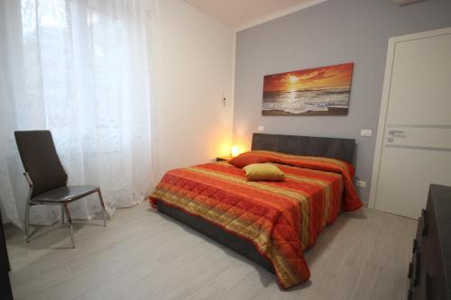 a bedroom with a bed and a chair in it at Sapore di sale, sapore di mare in Chiavari