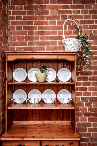 a wooden shelf with plates and a basket on it at Trivelles Waterhall Country Gatwick Hotel & airport parking in Crawley