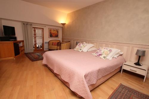 Schlafzimmer mit einem Bett mit weißer Bettwäsche und Kissen in der Unterkunft Domaine Jean Sipp in Ribeauvillé