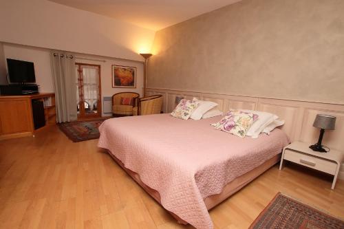 a bedroom with a bed with white sheets and pillows at Domaine Jean Sipp in Ribeauvillé