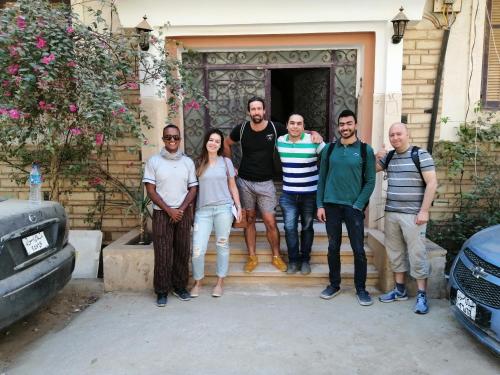 a group of people standing in front of a house at david hostel in Aswan