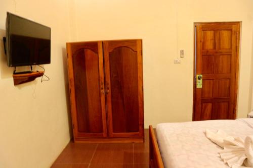 a bedroom with a bed and a flat screen tv at IRIS MOTEL in Tachilek