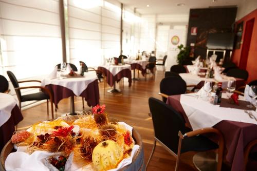 a dining room with tables and chairs and a plate of food at Vicenza Tiepolo Hotel in Vicenza