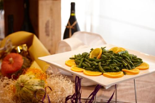 a plate of green beans and oranges on a table at Vicenza Tiepolo Hotel in Vicenza