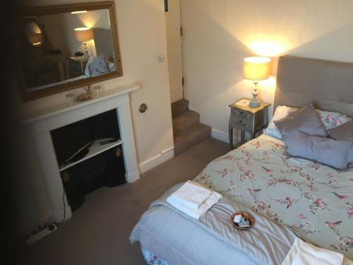 a bedroom with a bed and a fireplace at Holly Lodge in York
