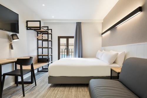 バルセロナにあるアクタ BCN 40のベッドとデスクが備わるホテルルームです。
