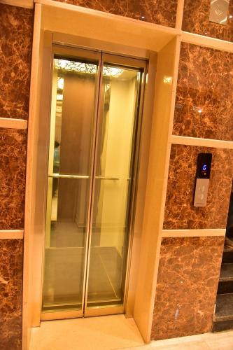a glass door in a building with a stone wall at Le Oak Inn in Mysore