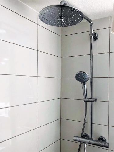 eine Dusche mit Duschkopf in einem Badezimmer in der Unterkunft Hôtel Gustave Colmar in Colmar