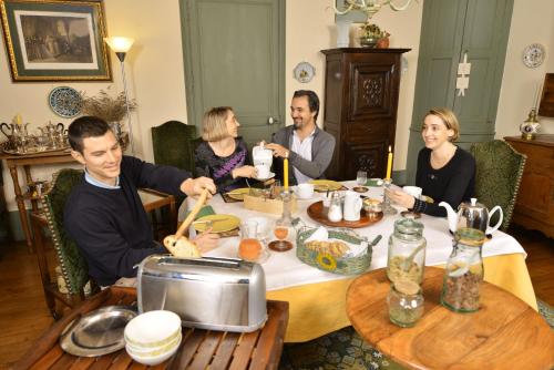 Un grupo de personas sentadas alrededor de una mesa comiendo en Le Masbareau, Chambre et Table d'Hôtes de Charme, B&B, en Royères-Saint-Léonard