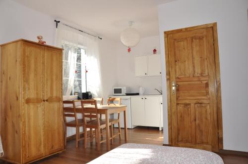 a kitchen with a table and a wooden door at Leśne Apartamenty in Zieleniec