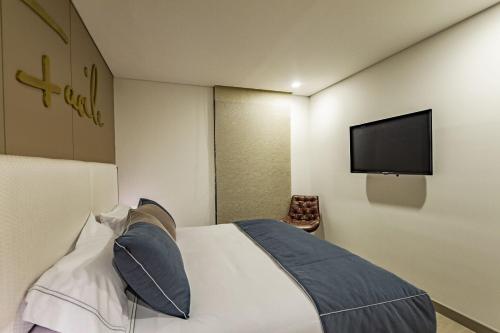 a hotel room with a bed and a flat screen tv at Apartametos FACILE in Bogotá