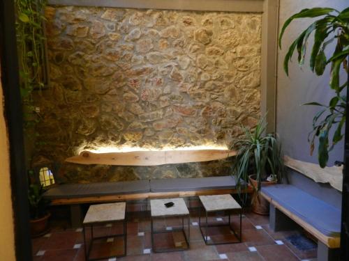 a stone wall with a bench and a surfboard on it at Villa Alicia Guest House in Málaga