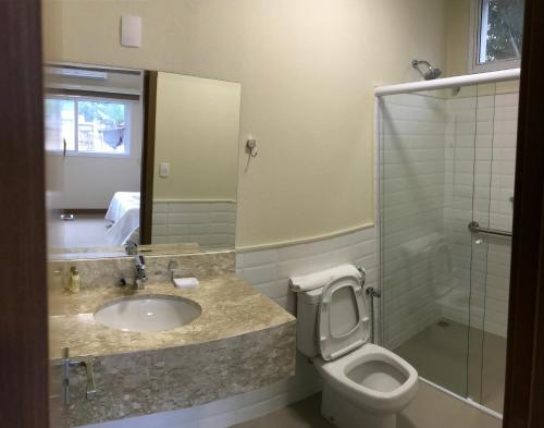 a bathroom with a toilet and a sink and a shower at Ipê Palace Hotel in Adamantina