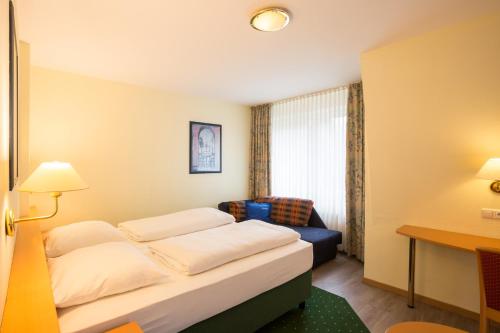a hotel room with a bed and a couch at Hotel Gremersdorf - Zum Grünen Jäger in Gremersdorf