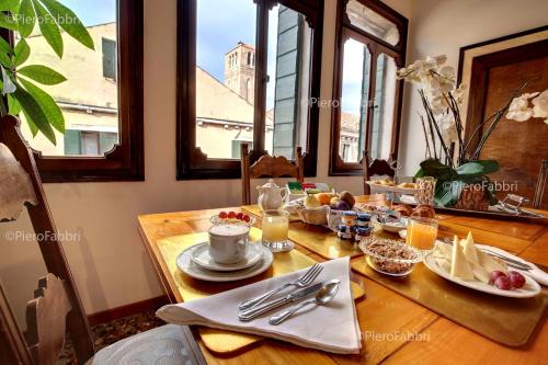 a dining room table with breakfast food on it at La Villeggiatura in Venice